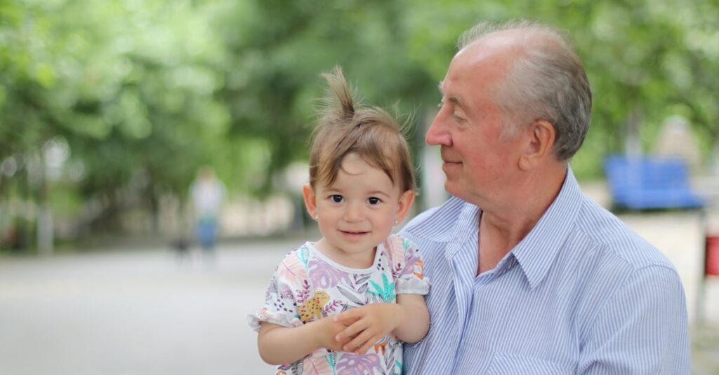A joyful moment with a grandfather holding his grandchild in a sunny park.